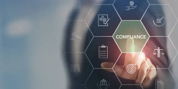 Businessperson touching a compliance icon in a hexagon-grid graphic with legal and audit icons