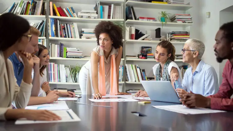 A diverse team of colleagues reviewing reports together around a conference table
